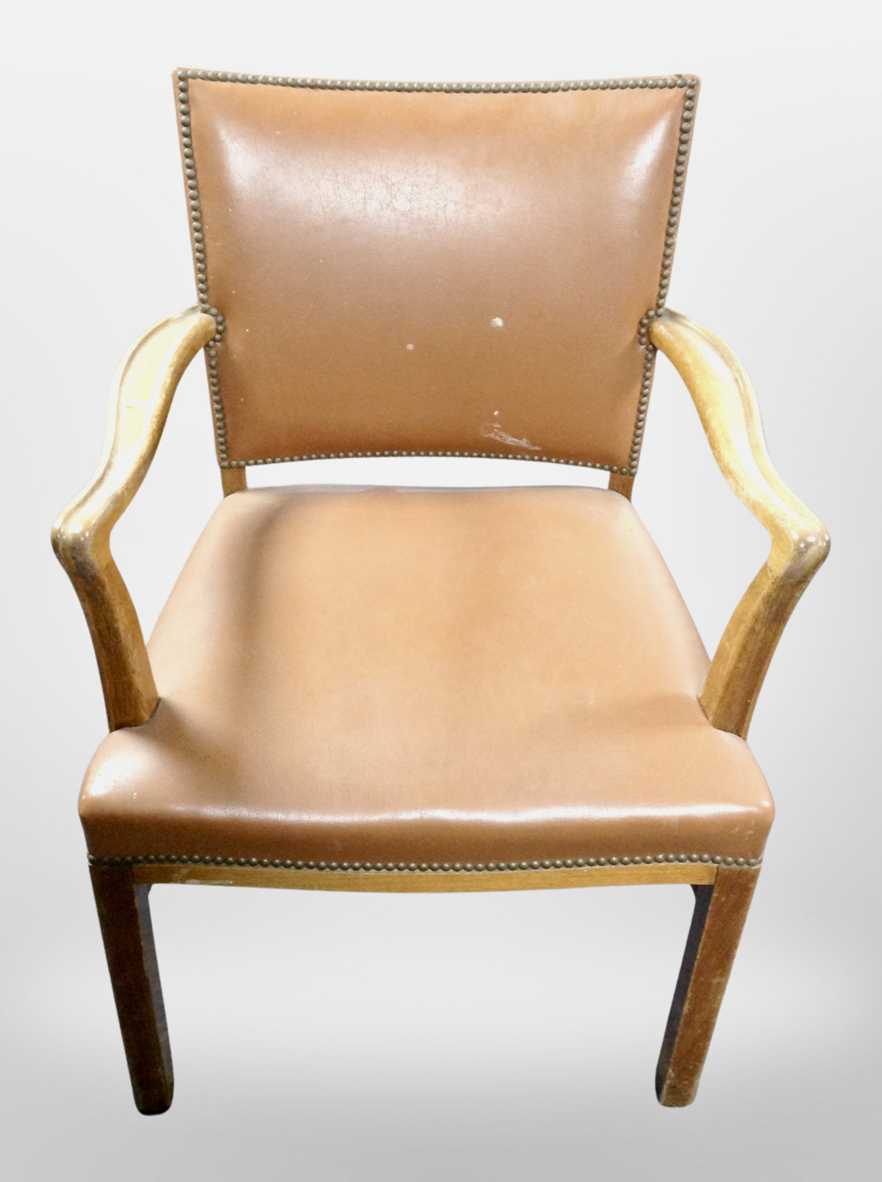 An armchair in studded tan vinyl