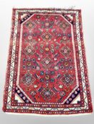 An Iranian woolen rug on red ground,