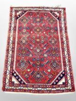 An Iranian woolen rug on red ground,