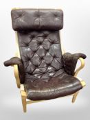 A 20th century Danish beech framed brown buttoned leather and canvas armchair