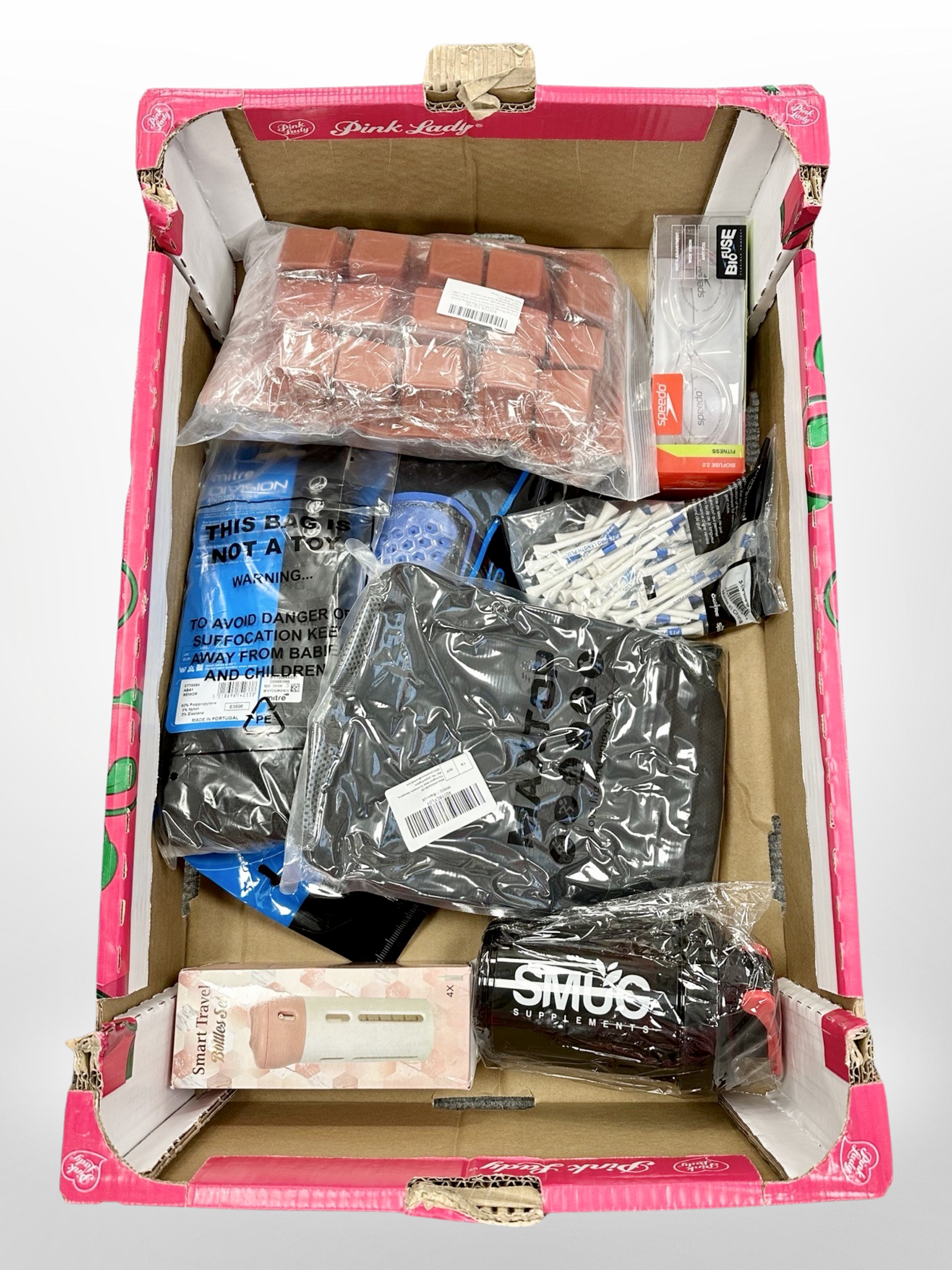 A box of new retail stock items - Swimming goggles, shin pads,