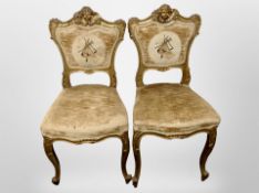 A pair of continental gilt wood and gesso framed salon chairs, with needlework back rests.