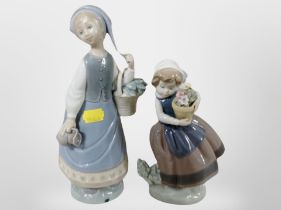 Two Lladro figures of girls carrying flowers.