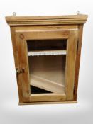 A glazed pine single door wall cabinet,