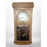 An early 20th century oak 8-day wall clock with silvered dial.