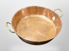 A copper twin-handled shallow cooking pan, diameter 34cm.