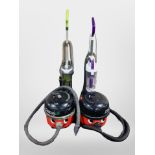 Two Henry vacuum cleaners, and two other upright vacuums.