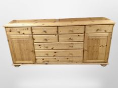 A contemporary pine sideboard fitted cupboards and drawers, length 177cm.