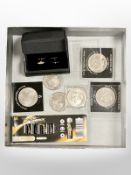 A box of commemorative coins, pair of cufflinks, sealed pack of AA batteries.