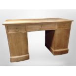 An early 20th century Danish oak serpentine front twin pedestal desk, width 140cm.