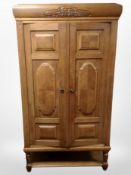 An early 20th century panelled oak double door cabinet with shelved interior,