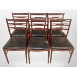A set of six reproduction teak ladder back dining chairs with black vinyl seats