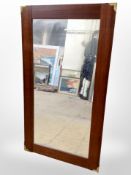 A mahogany rectangular mirror with brass capped corners,