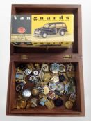 A brass inlaid box containing assorted pin badges and a Vanguards diecast Morris Minor Traveller in