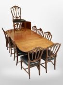 A reproduction mahogany extending dining table with two leaves,