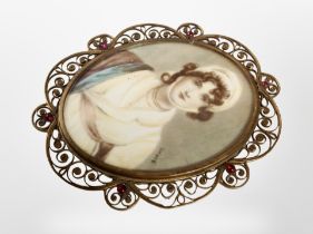 A 19th century portrait miniature of a lady wearing a bonnet in brass scrollwork frame,