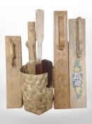 A wicker basket containing four Scandinavian carved oak mangle boards, a rolling pin, etc.