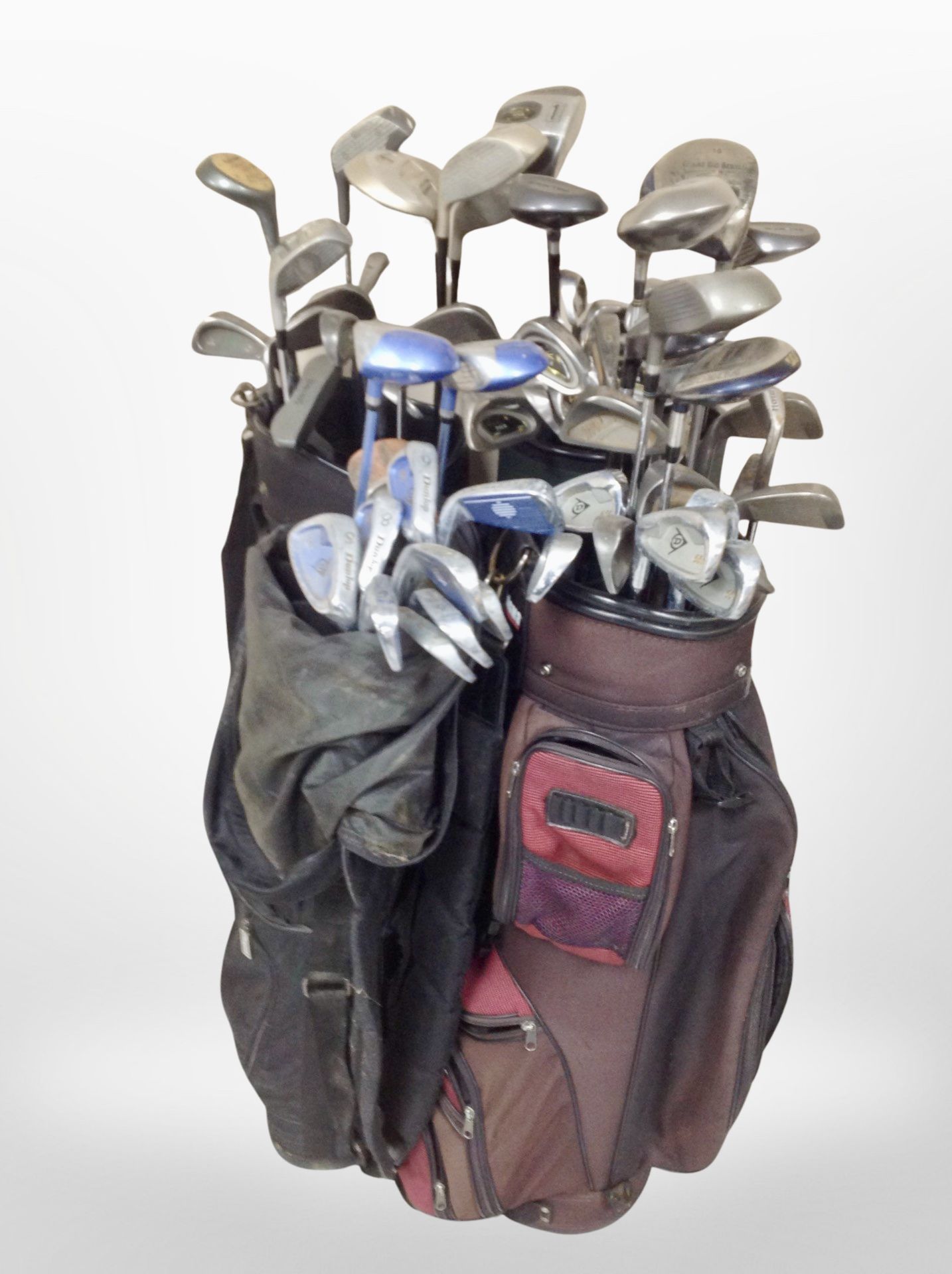 Several golf bags containing assorted drivers and irons including Dunlop, Palmer,