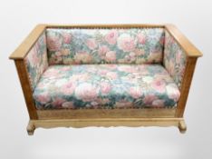 An early 20th century Danish oak hall settee in floral upholstery,