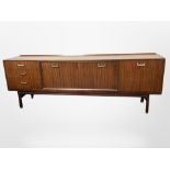 A 1970's teak low sideboard, fitted cupboards and drawers,