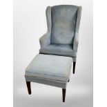 A 20th century Danish wing back armchair and matching footstool upholstered in sky-blue dralon