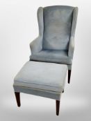 A 20th century Danish wing back armchair and matching footstool upholstered in sky-blue dralon