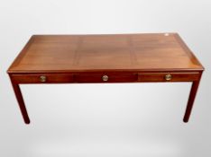 A reproduction mahogany low coffee table, fitted three drawers,