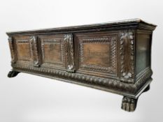 An 18th century continental carved oak cassone raised on lion paw feet,