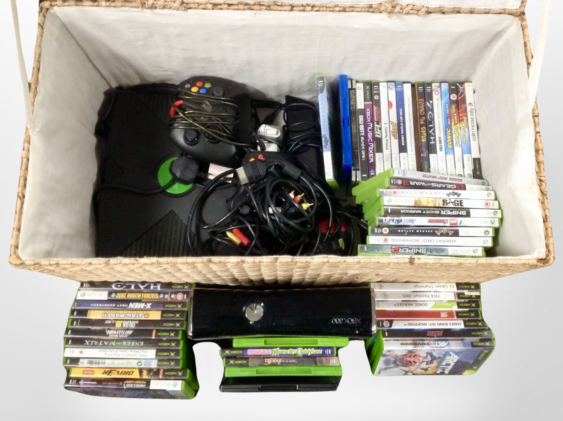 A wicker hamper containing an Original Xbox 360 console and assorted games.