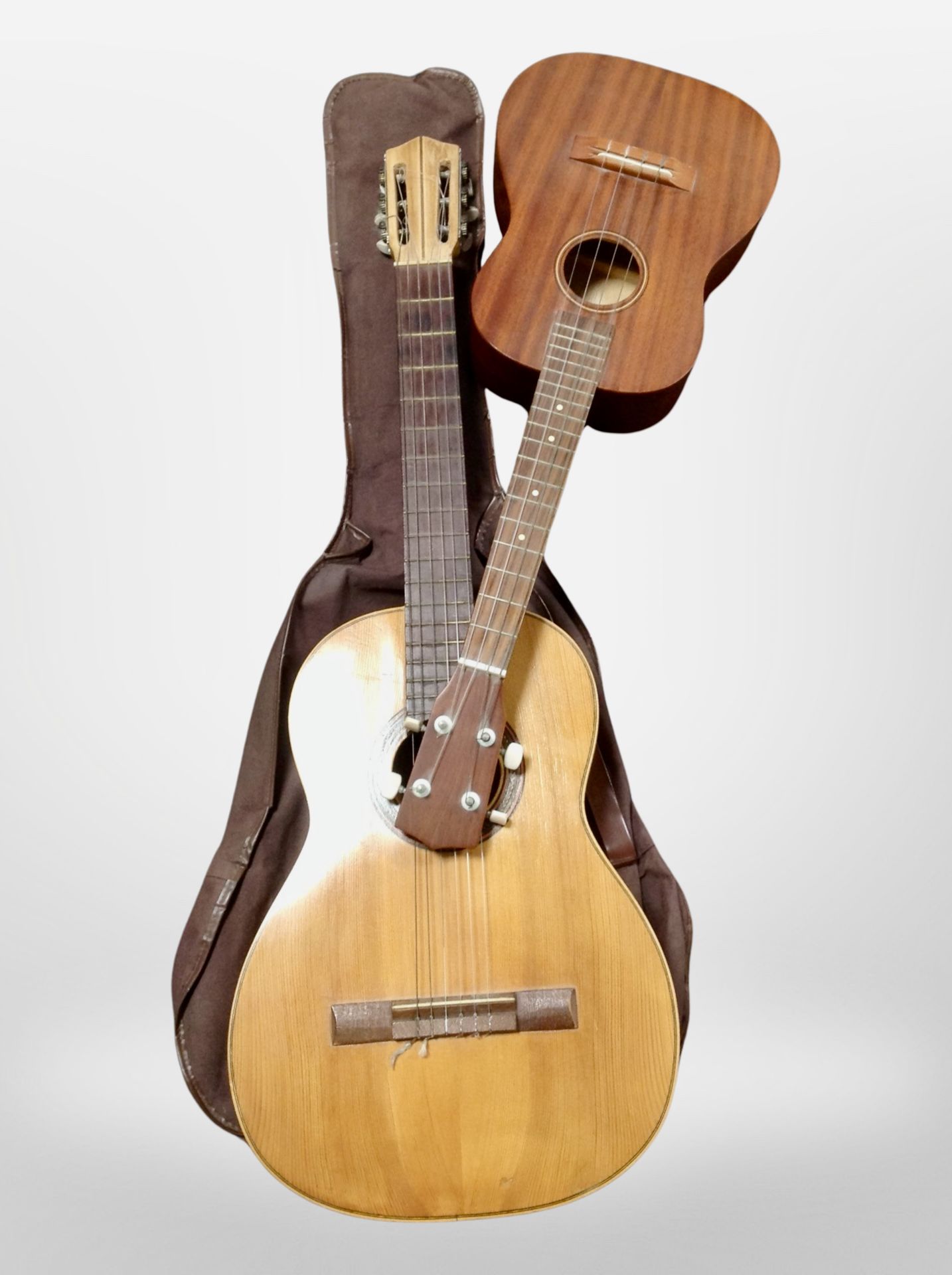 A Spanish classical guitar and another four-string guitar.