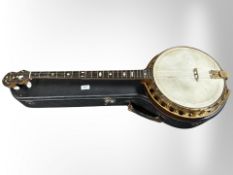 A Gedson four-string banjo in hard carry case.