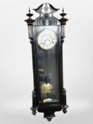 An ebonised Vienna style wall clock with enameled dial, height 121 cm.