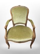 A continental carved beech salon armchair in dralon upholstery