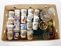 A box containing several glass paperweights, glass decanter,