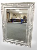 A silvered-framed bevelled overmantel mirror, 122cm x 92cm, and one other mirror.