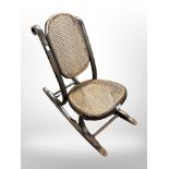 A 19th century child's rocking chair with cane seat and back rest