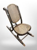 A 19th century child's rocking chair with cane seat and back rest