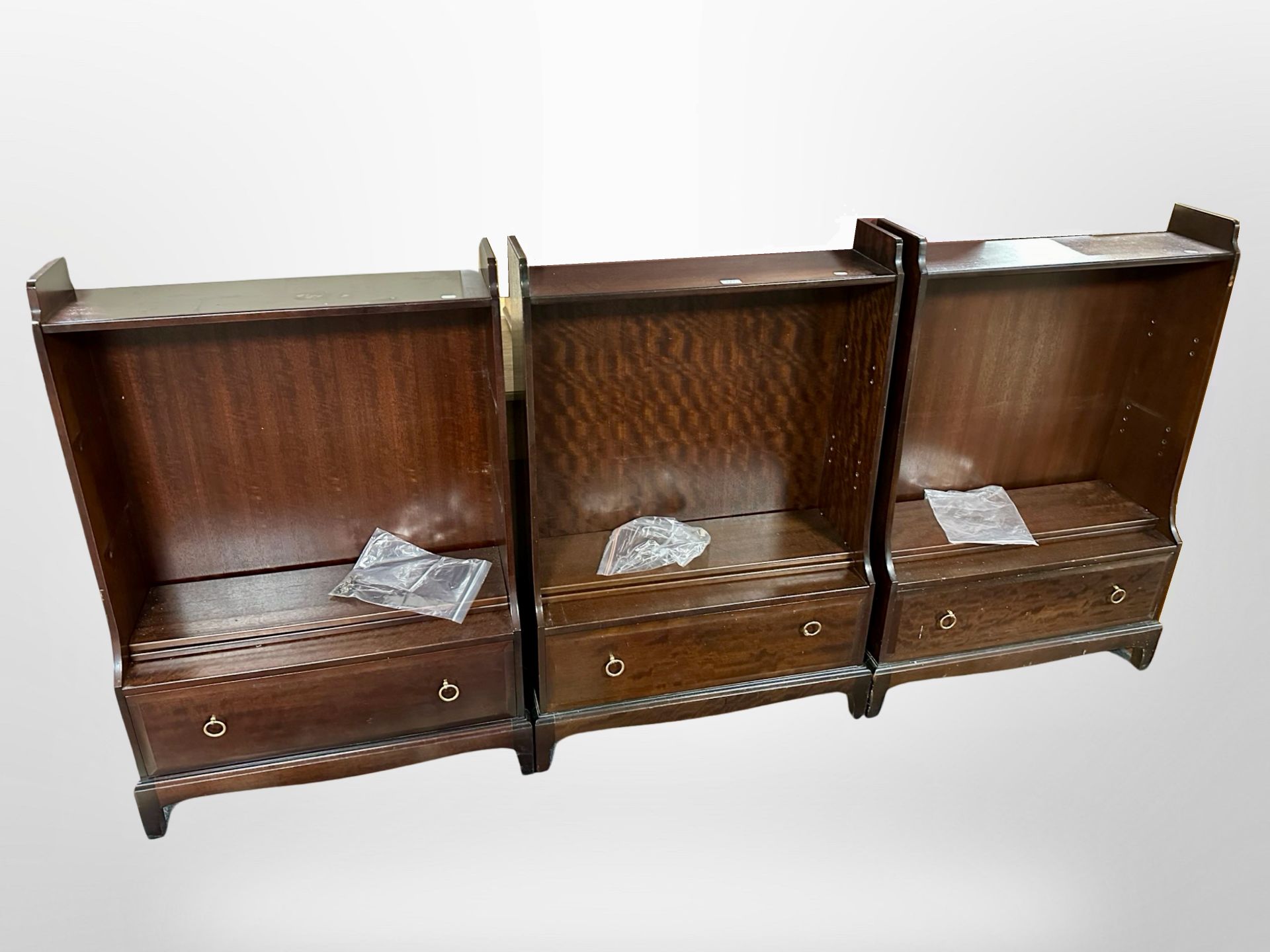 Three Stag Minstrel open bookcases fitted with drawers beneath, each 75cm wide.