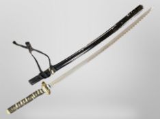 A reproduction Japanese katana in lacquered scabbard.