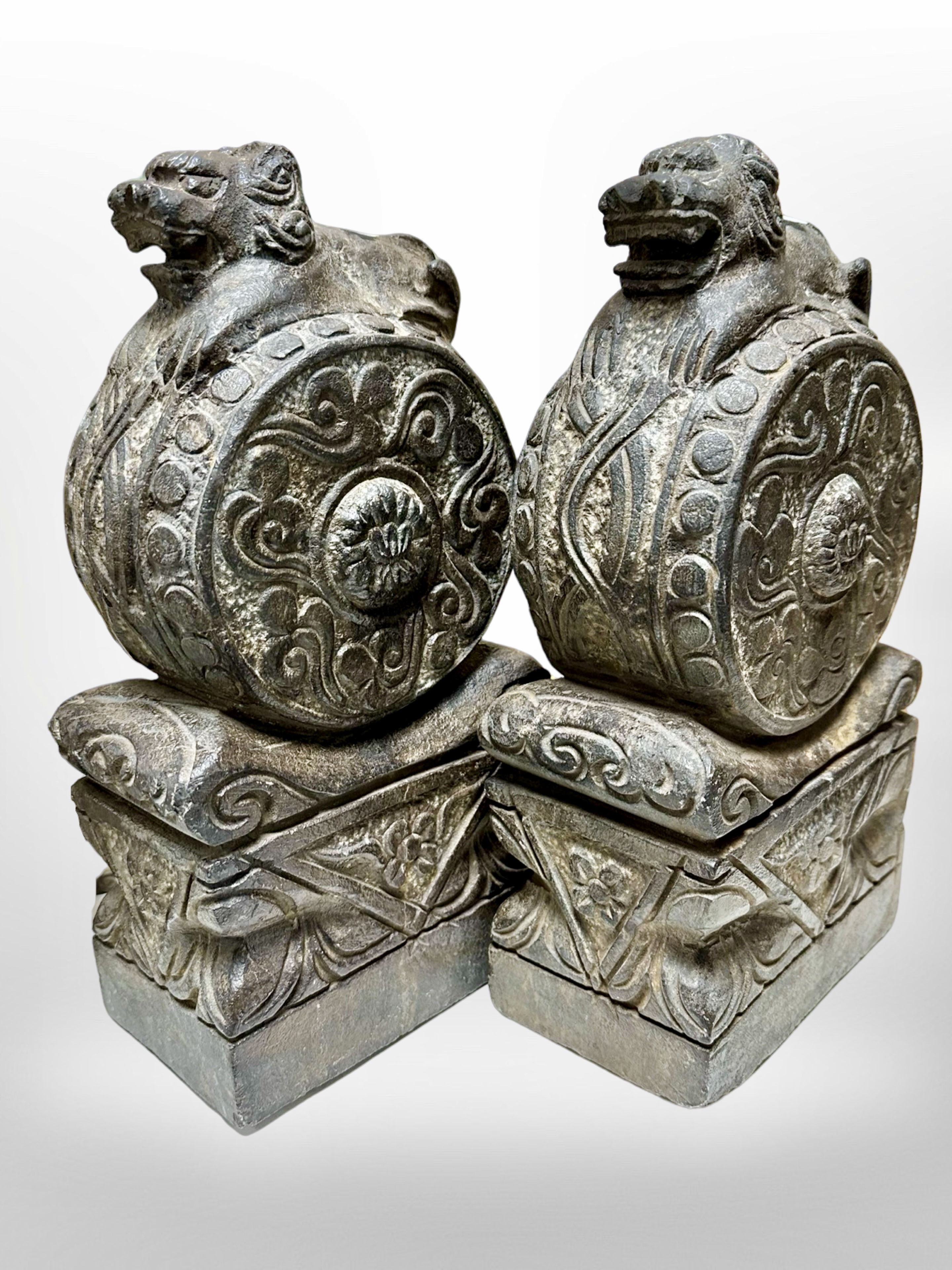 A pair of cast composition finials, surmounted by Chinese Foo dogs, height 32cm.