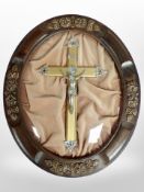 A crucifix in oval convex frame, 50cm x 41cm.
