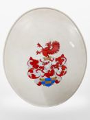 An oval metal plaque painted with an armorial crest, length 73cm.