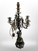 A bronze and marble table lamp with cherub support with five candle sconces around a central wired