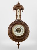 A carved walnut barometer.