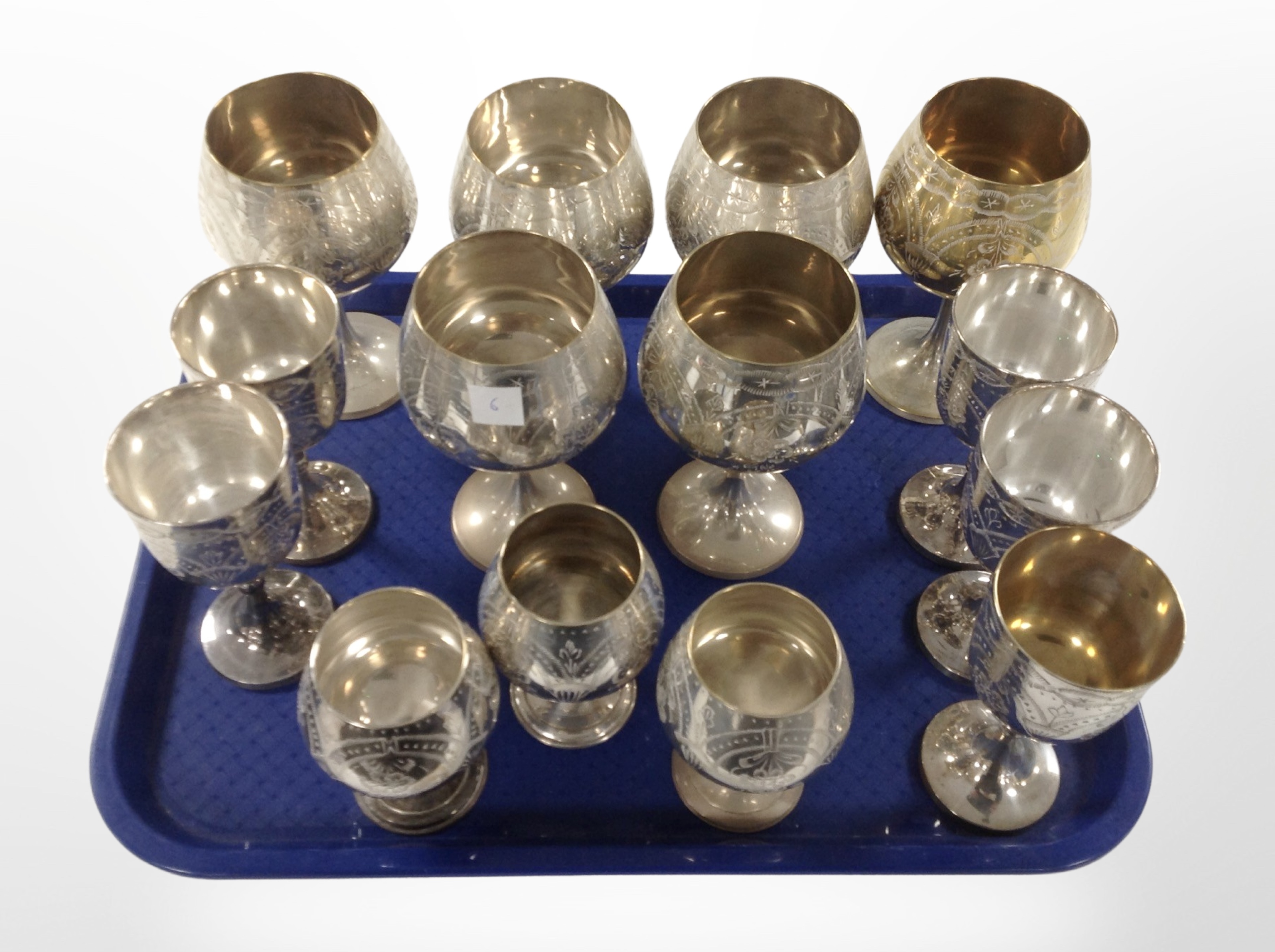 A collection of silver-plated and brass goblets.