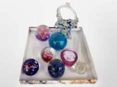 A group of glass paperweights including Caithness, together with a glass basket and slender vase.