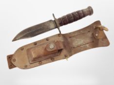 A hunting knife, blade length 13cm, with a wooden and iron handle in a leather sheath.