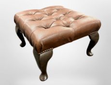 A brown buttoned leather footstool,