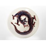 A William Moocroft plate decorated with a dragon, diameter 26 cm.