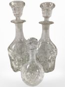 A pair of crystal decanters with stoppers, and one other smaller example, height 30cm.